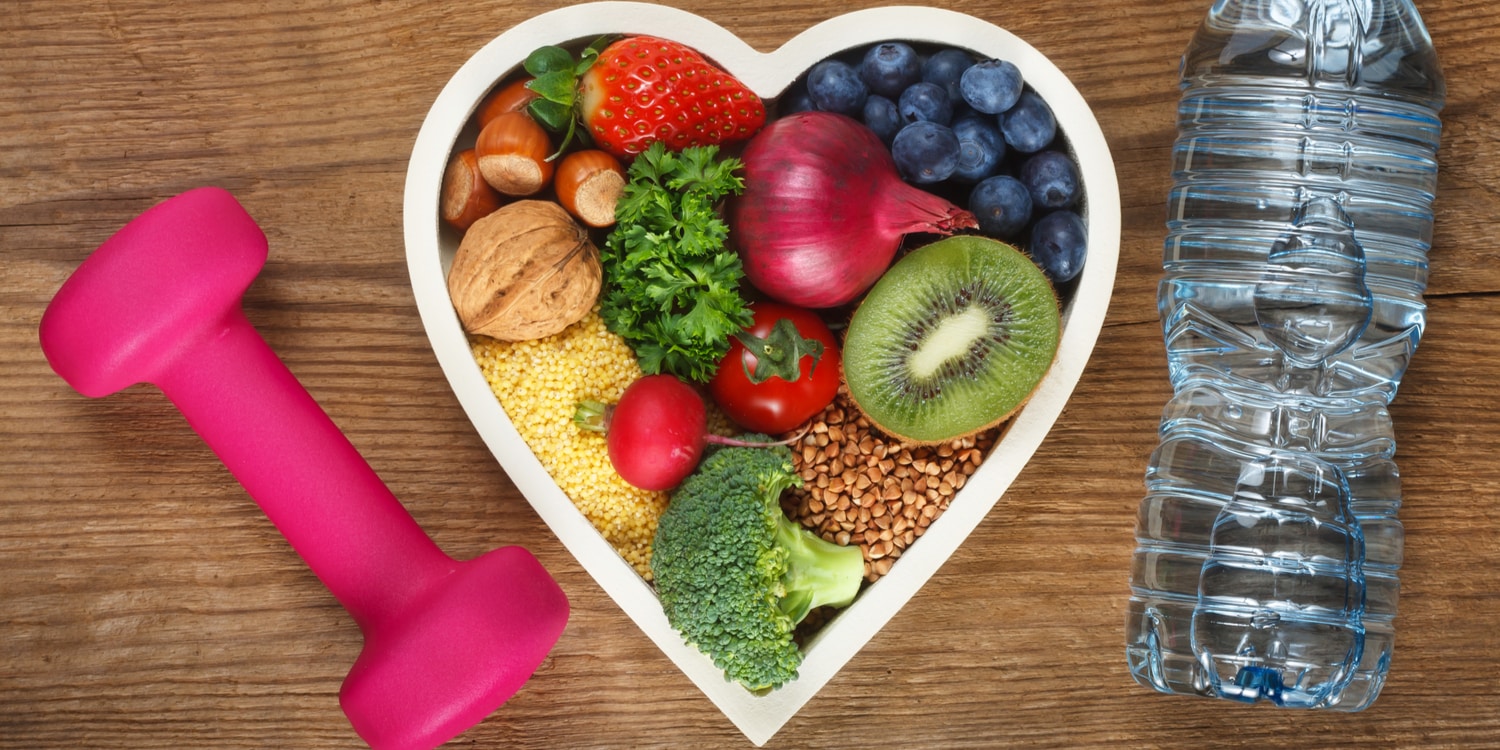 A heart-shaped bowl with healthy food next to a weight and a water bottle, representing health tips for truckers