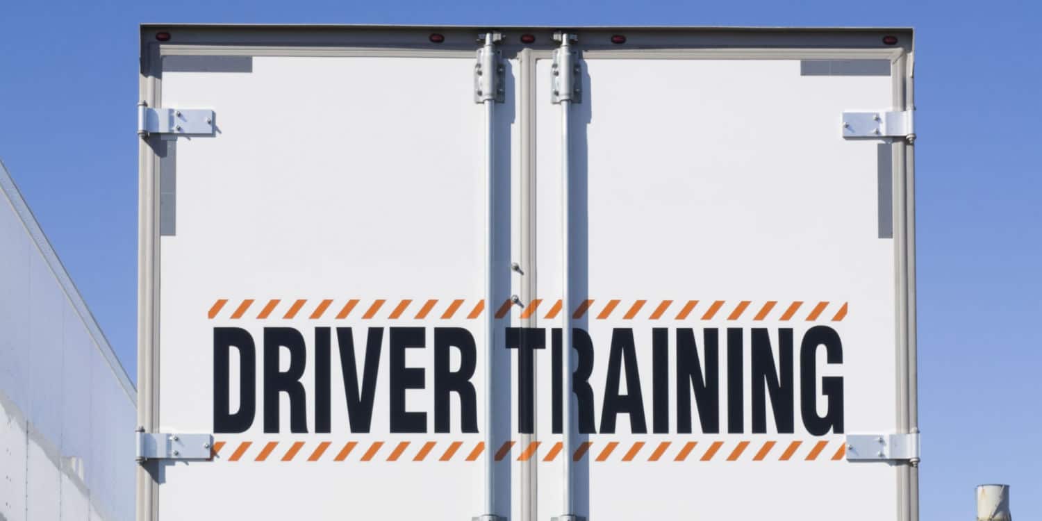 The back of a semi-truck that reads driver training showing what to expect during trucking company training