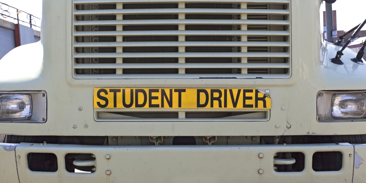 Semi truck with "student driver" sticker on the front.