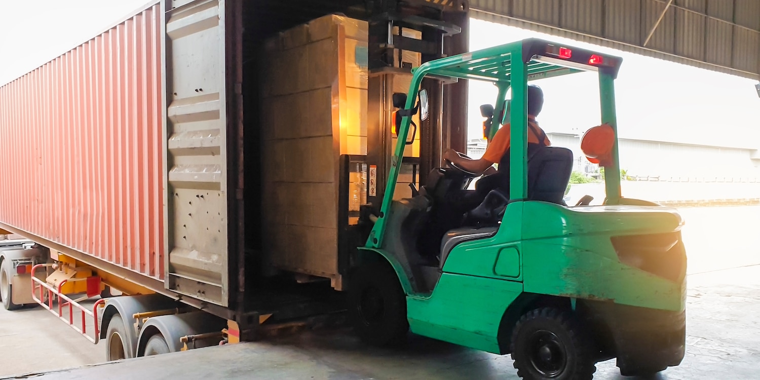 A person unloading freight with a forklift