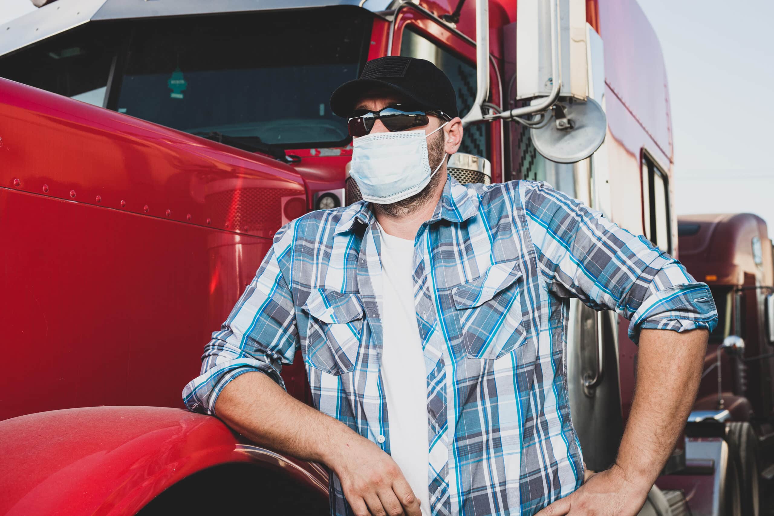 Truck Driver With a Mask Trucking in Times of Crisis